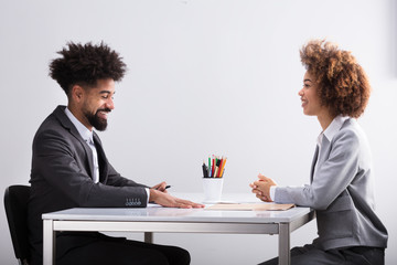 Two Businesspeople Having Conversation In Office