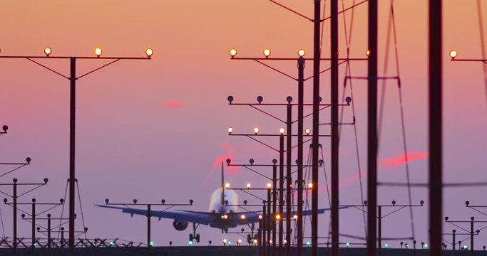 Commercial jet airplane plane landing in airport at sunset Los Angeles CA 4K UHD