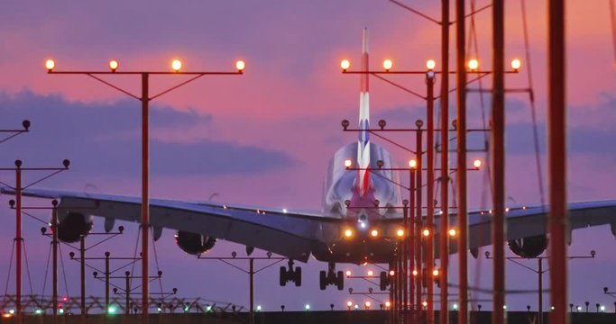 Jumbo jet airplane plane landing in airport in Los Angeles at sunset. 4K UHD