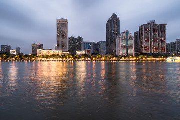 Office buildings and hotel tower reflect in the water of the Pearl river that crosses the Guangzhou downtown district