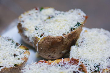 Unpeeled baked potato with cheese.