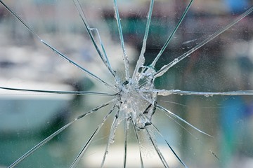 Star burst effect cracks in a glass panel in the marina area, Albuferia, Algarve, Portugal.