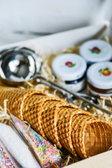 gift set for ice cream in a box: waffle cups, spoon for ice cream, sprinkles and topping