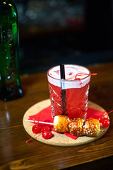 cocktail glass on the wood table in the bar. Slow motion