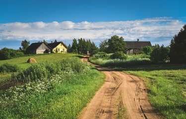 Obraz premium House and road to home in beautiful countryside against the blue sky.