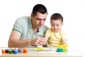 young smiling father painting with kid son