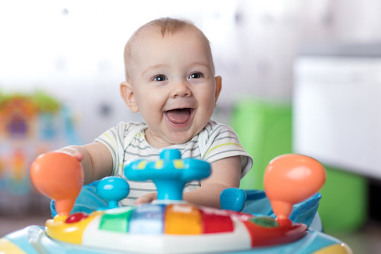 funny baby boy playing in baby jumper