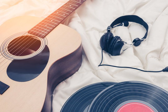 acoustic guitar, record & headphone on white bed. music background
