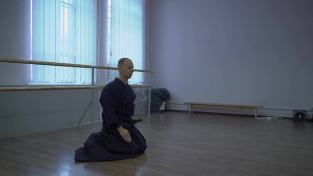 The Master Kendo Sits on the Floor and Lies Before Him Katana's Sword in the Sheath