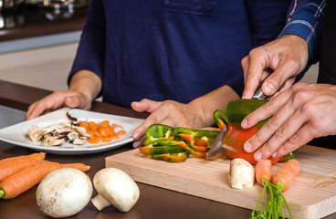 Young couple cutting vegetables in the kitchen to prepare food