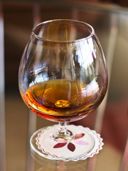 A glass of cognac on a clear table on a white napkin