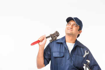 Indian plumber at work with Pipe wrench or plumbing spanner, standing isolated over white background
 - Powered by Adobe