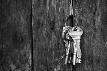 Key chain hanging with wood fence texture background in black and white tone