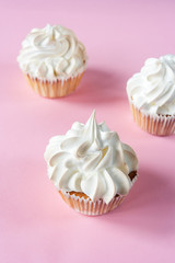  Cakes with meringues on a pink background. Close up. Place for text.