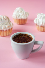 Coffee espresso in a white cup and cakes with meringues on a pink background. Close up. Gentle colors. Elegant  dessert. Serving option. Holiday. Wedding table.