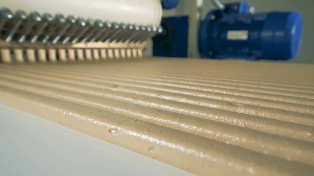 Sweets rows running down from a working conveyor. 4K.