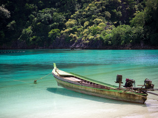 Wooden boat on white sand beach at the sea in sunny day for travel and holiday concept.