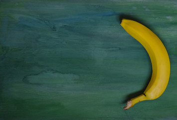 bright yellow banana on a green background