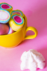 marshmallows of coloress on pink background