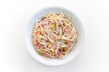 spaghetti with ham and courgette flowers with cheese, top view of the plate on white background