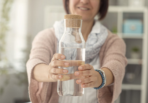 Female holding water bottle  in kitchen