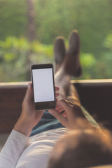 Man lying on a sofa and using cellphone.