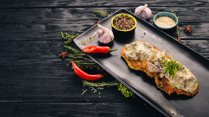 Potato pancakes with pork. Hot appetizers. Top view. On a black wooden background. Copy space.