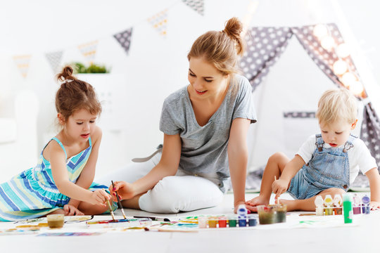 children's creativity. mother and children draw paints in   playroom