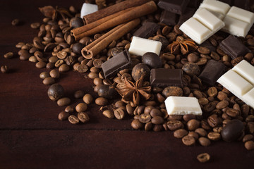 Dark and White Chocolate, Coffee Beans, Chocolate Balls, Spices, Cinnamon on the Old Wooden Table