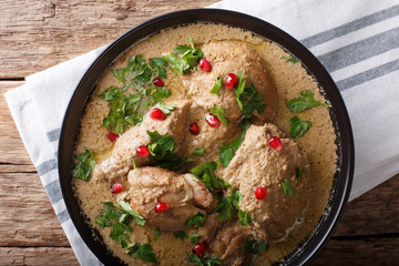 Delicious Georgian satsivi with chicken and pomegranate close-up in a bowl. Horizontal top view