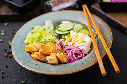 Salad from eggs, fried fish and fresh vegetables. Asian cuisine.