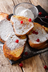 Brazilian sweet Rabanadas toast with powdered sugar and cranberries close-up. vertical