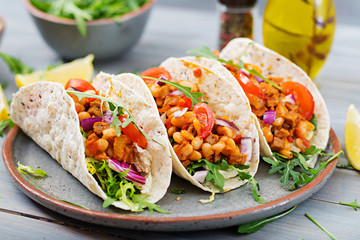 Mexican tacos with beef, beans in tomato sauce and salsa