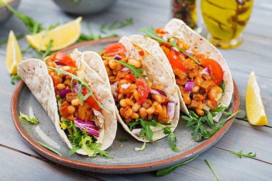 Mexican tacos with beef, beans in tomato sauce and salsa