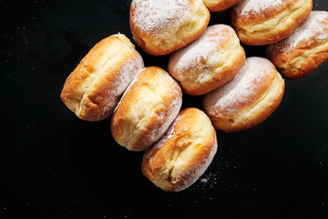 Closeup shot of sufganiyot donuts with jelly on black background