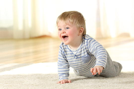Baby crawling and laughing on the floor at home
