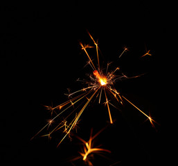 Close up one firework sparkler over blue bokeh