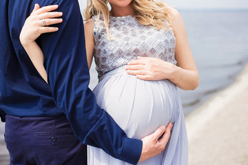 belly of a pregnant girl on a background of water