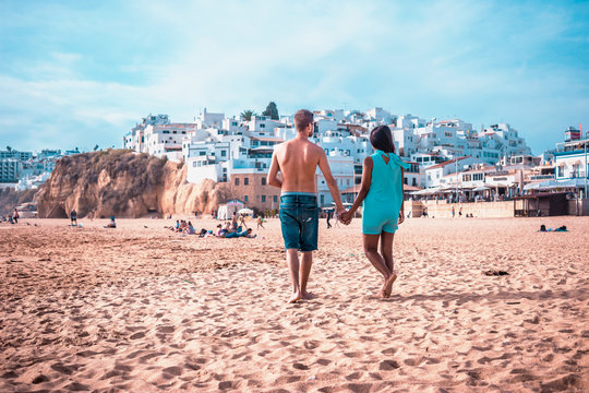 Happy young couple walking on the beach of Albufeira Algarve Portugal