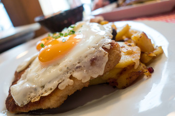 Hamburger Schnitzel aus Schweinefleisch mit Spiegelei und Röstkartoffeln