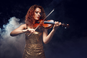 Fototapeta premium Violinist girl performs on stage.