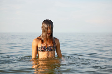 Girl with wet hair in the sea.