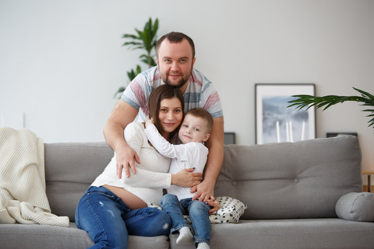 Picture of happy family with son on gray sofa