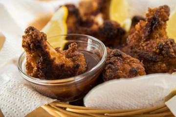 Scharfe Hähnchen Flügel im Korb mit Ketchup und BBQ Soße