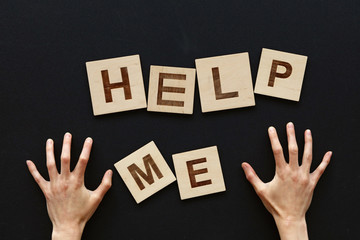 Woman hands and word HELP ME over black