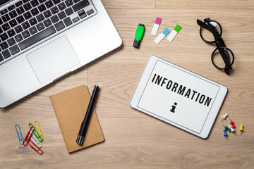 Information written on tablet lying on desk as flatlay
