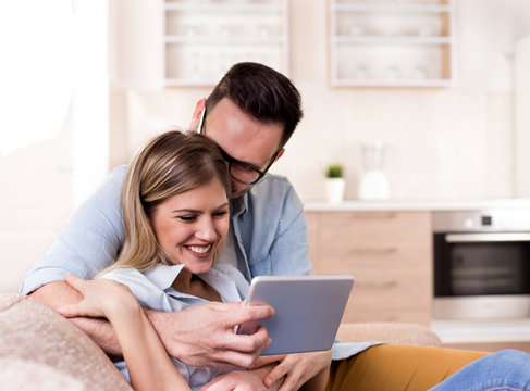 Young couple looking at tablet at home