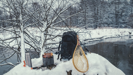 A picnic on a fishing trip, on a snow-covered winter river.