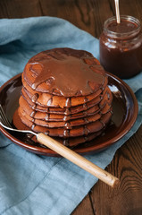 Chocolate fluffy pancakes with chocolate sauce. Blue background.