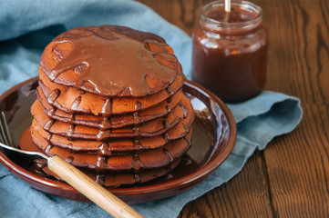 Chocolate fluffy pancakes with chocolate sauce. Blue background.